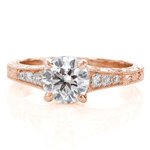 This ornate ring is fully detailed with an elegant hand engraved pattern all the way around the band. There are three side stones that graduate in size to match the flare of the band as it reaches the 1.00 carat center stone. The four high polished prongs securing the center diamond compliment the band beautifully.