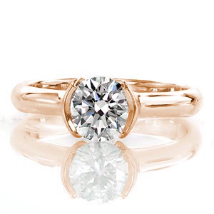 Calla is a contemporary solitaire with its sophisticated half-bezel setting. Raised shoulders contour around the stone adding dimension and security to the diamond. On the side view, the open curve of the band displays the lovely silhouette of the round brilliant. 