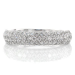 Three rows of micro pavé diamonds shine vibrantly along the length of this signature wide band. Highly versatile, this unique band can stand alone as a statement piece or compliment a wedding band. The width of the band tapers towards the bottom of the ring for a comfortable fit. 