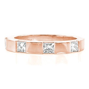 Design 2023 has four princess cut diamonds that total 0.60 carats. Crafted in 14k white gold, the band has crisp edges and an overall streamlined appearance. The alternating look of diamond and high polished areas would compliment any ring it is paired with.
