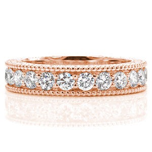 This classic band is made elegant by the engraved pattern on the side faces of the ring. The diamonds securely fashioned with shared bead-set prongs add up to 1.50 total carat weight. The edges of the design are refined with beaded milgrain texture that beautifully accents the prongs of the stones. 