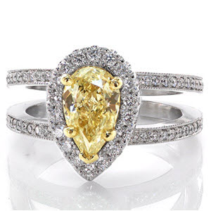 This luxurious design features a fancy yellow pear shape diamond center held in place with 18 karat yellow gold prongs. This 1.00 carat pear cut stone is surrounded by a scintillating micro pavé halo. The center setting is upraised to allow a wedding band to sit flush against the split shank diamond band.