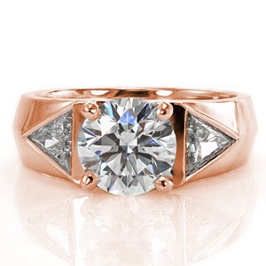 This contemporary wide band ring features three diamonds set on a mock-knife edge band. The center diamond is a 2.00 carat round brilliant cut diamond. The two side stones are trillion cut diamonds which accent the shape of the ring. The luster of the high polished metal is a wonderful contrast to the diamonds.