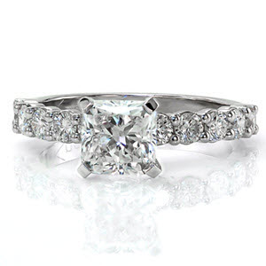Kelsey Marie is a classic beauty with round brilliant cut diamonds in prong settings adorning the band. The center stone is a 1.50 carat radiant cut in an elevated setting. Vibrant stones dazzle with a prism of colors in any light. The 14k white gold metal reflects the same brightness as each of the diamonds.
