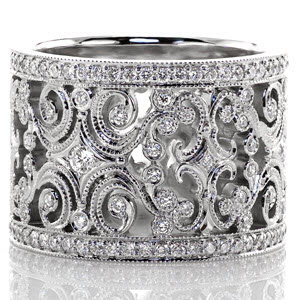 Caledonia is a sensational ring fashioned from large, intricate filigree curls and diamonds. The edges of the pattern are textured with milgrain to refine the look, and there are small bezel set diamonds throughout the band. Each edge of the band is finished with a row of micro pavé to frame the design.