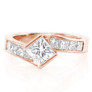 Design 2088 boldly displays the crisp lines of a formal 1.00 carat princess cut diamond. The half bezel setting twists to secure the top of the center stone in a kite-set position. Square princess cut side stones are channel set into the handcrafted 14k white gold band.