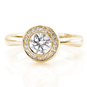 Yellow gold halo engagement ring with bezel set round diamond in Cleveland. 