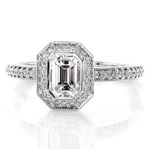 The bright-cut bead-set diamond halo captivates a stunning 0.75 carat emerald cut center diamond in the Emerald Bezel Elegante. Divine lines with milgrain edges join the comfortable Euro shank fit and pedestal halo providing this ring with a stunning profile.