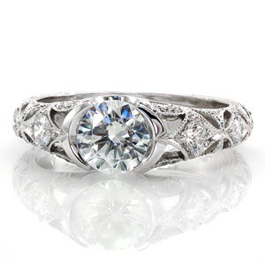 Custom engagement ring in Arlington with half bezel round center stone and embellished diamond band.