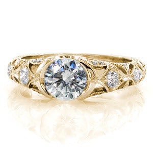 Antique engagement ring in Indianapolis with half bezel center stone and intricate diamond band. This beautiful yellow gold engagement ring features a star burst pattern on the band set with diamonds.