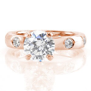 Providence contemporary custom engagement ring with a round diamond center held by four prongs and a band with staggered flush set round diamonds.