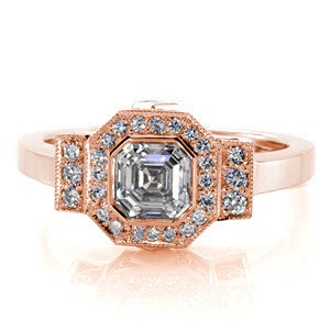Art Deco inspiration is reflected in Design 2163. The center displays a full bezel set, .90 carat, asscher center with a octagonal micro pavé diamond halo. The design merges into a rectangular row of bead set diamonds and polished band. Two carrÃ© cut diamonds and filigree curls decorate the sides.  