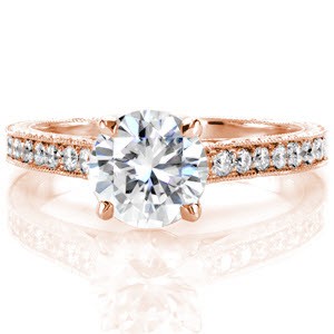 This pleasing design is vintage-inspired with its 1.00 carat round brilliant cut center diamond in a cathedral setting. The band gracefully curves up to the raised setting and has micro pavé on the top. The sides of the band are adorned with fascinating hand engraving and hand made filigree curls.