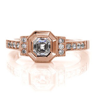 This design is inspired by the art deco style. The 0.75 carat asscher cut center stone is framed by a wide bezel which has been given a high polish to mimic the cascading, step cut facets of the diamond. The two bars to either side of center and the band are detailed with micro pavé and milgrain edging.