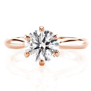 The prestige of a classic solitaire with a stately 1.50 carat round brilliant cut diamond sets Design 2171 apart from others. Crafted in 14k white gold, an iconic 6 prong setting is given a twist with the added detail of a band which slightly arches upward to join the basket. This elegant design is truly timeless.
