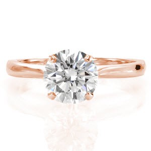 Filiano is a classic solitaire setting with a touch of flair. The narrow band arches to a point for a stylistically pleasing design element. The reverse V-shaped prongs elegantly display a 1.25 carat round brilliant diamond. The luster of the high polished band compliments the radiance of the center stone.    