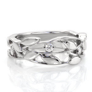 This nature inspired wide band is a graceful design that combines organic metal work detail within the unique pierced pattern. Diamonds are nestled among the woven vines and leaves for a touch of enchantment. The gentle flow of the pattern is mesmerizing.
