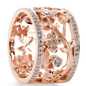 Unique custom wide band ring in Las Vegas with bead set diamond rails surrounding a diamond set floral designed center.