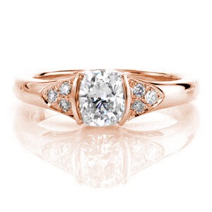 The rich yellow color the 14k gold is a striking contrast to the vibrant white diamonds. The 0.90 carat cushion cut is securely fashioned in a half bezel giving the side view a stunning silhouette of the center stone. The accent diamonds and filigree scrolls lend a sophisticated touch to this antique inspired design. 