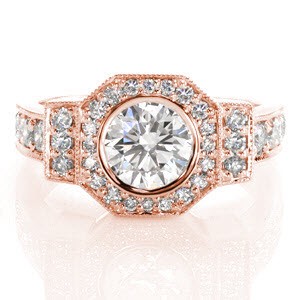 The sleek contour of the octagon halo captures the bold geometric shapes of the Art Deco era. The bezel set round brilliant diamond is a sharp contrast to the soft milgrain texture adorned along each edge. Bead set diamonds outline the band and patterns of this design for a radiant silhouette.  