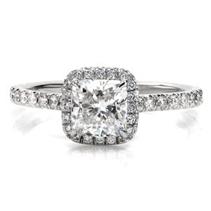 Our gleaming platinum, bright cut, micro pavé, diamond engagement ring emits classic elegance. A 1.00 carat cushion cut center stone is held with four prongs, and is surrounded by a delicate diamond halo. The diamond band is structured to fit a wedding band that can sit closely next to it. 