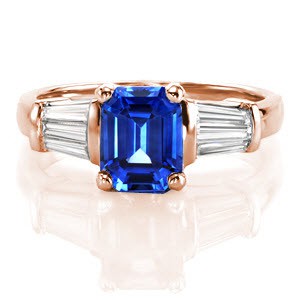 Design 2270 incorporates crisp faceting and elegant hues of an imperial blue hue seamlessly. A 2.00 carat emerald cut sapphire is set within a traditional four prong setting and framed with tapered baguettes. The 14k white gold band tapers for a comfortable fit.