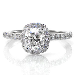 A unique, elegant ring with a V-cut micro pavé band designed to dazzle. The V-cut is a style of hand cut pavé which allows the maximum amount of light into the diamonds and results in radiant stones. This platinum ring features a 1.00 carat rectangular cushion cut center diamond set into a halo.