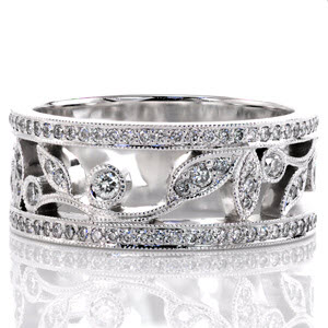 Micro pavé diamonds frame the naturalistic arrangement down the center of the band. The outline of the vine is decorated with leaves and circular patterns. Each leaf and circle features round brilliant diamonds for sparkle and fire. Milgrain texture adds dimension to all the outside edges.  