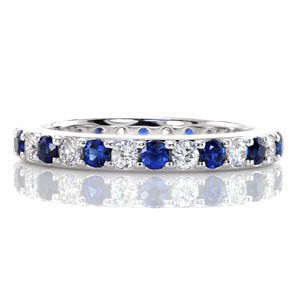 The Sapphire Eterno captivates the eye with a continuous pattern of sparkling white diamonds and natural blue sapphires. Crafted in 14k white gold, the round gemstones are set within unique shared prongs. The ring faces are finished with a high polish.