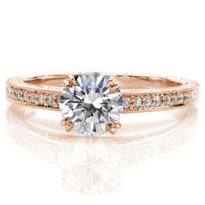 This graceful cathedral setting is vintage-inspired with tantalizing hand engraving on the top and sides of the band. The upper section of the band is detailed with bead set diamond and filigree on the sides. The center stone is a 1.00 carat round brilliant cut diamond with double prongs. 