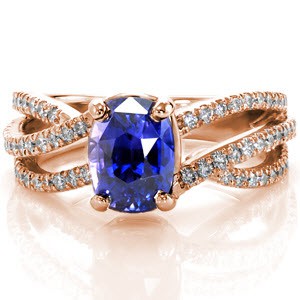 Adriana Sophia features a breathtaking 2.00 carat cushion cut purplish blue sapphire. The mysterious hue of the sapphire center is the focal point of this 14k white gold setting. Three micro pavé bands curve and rise to the top of the band giving the band grace and movement.   