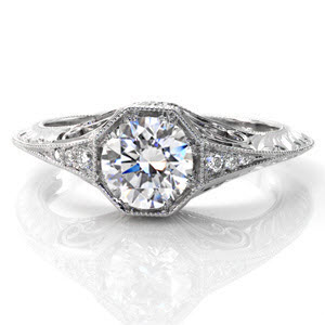 This charming, vintage-inspired design has a 0.75 carat round brilliant cut center diamond in a unique octagonal setting. Side stones taper into a graceful knife-edge band which is edged in milgrain for texture and a refined finish. The sides are adorned with hand engraving, filigree, and diamonds.