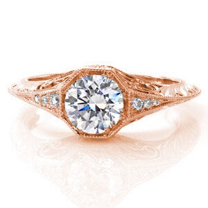 This charming, vintage-inspired design has a 0.75 carat round brilliant cut center diamond in a unique octagonal setting. Side stones taper into a graceful knife-edge band which is edged in milgrain for texture and a refined finish. The sides are adorned with hand engraving, filigree, and diamonds.