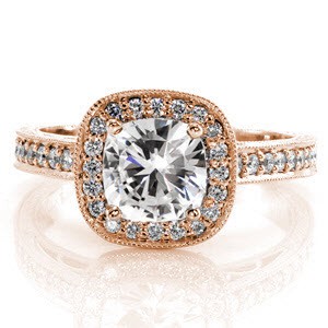 Our classically elegant Gardenia design features a 1.0 carat cushion center diamond with a surrounding micro pavé diamond halo. The diamonds continue along the side of the ring as well as under the center stone. The piece is finished with filigree curls, milgrain and bright cut hand engraving. 
