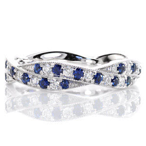 Crafted in 14k white gold, Design 2305 captures the rich, cobalt blues within its round sapphires. Alternating in arrangement, the round cut diamonds highlight the deep blue. The two woven bands are detailed with hand applied milgrain to bring the finest finishing touch.