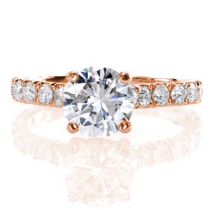 Graceful platinum lines unite in our Adora Design. U-Cut prongs hand-formed by our jewelers, securely fashion diamonds along the length of the band.  Up-swept shoulders join an alluring four prong basket which displays a 1.20 carat round brilliant cut center diamond that is absolutely breathtaking!