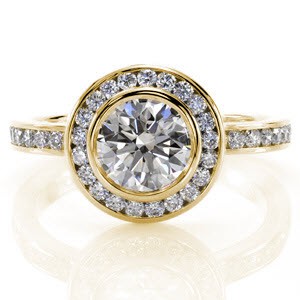 Custom created classic engagement ring with a bezel set round center diamond surrounded by a channel set diamond halo and diamond band in St Louis.