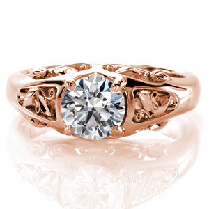 This chic design is a 0.75 carat round brilliant cut diamond solitaire. This eye-catching band is detailed with unique filigree featuring slender scroll curls, leaf patterns, and full ribbon curls. This combination of elements unites beautifully in six different pockets on three sides of the ring.