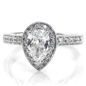 The Pear Valencia is an antique inspired design with a uniquely shaped center stone. The 1.00 carat pear center diamond makes this a statement piece. The micro pavé halo and band are combined with hand engraving and filigree for a timeless feel. The edges of the band are textured with milgrain. 