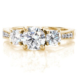 Charlotte three stone engagement ring with round diamonds and milgrain edges in yellow gold.