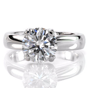 Breathtaking with classic simplicity the Jill Dianne design features a 1.50 carat round brilliant cut diamond. This solitaire is set with reverse V-prongs above a wide, high polished band. The luster of the band compliments the vivacious fire and brilliance of the center stone. 