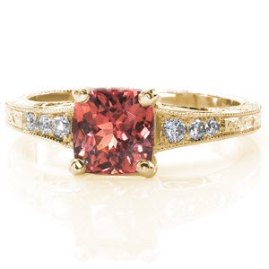 Antique inspired custom engagement ring in Dayton with a hand engraved and filigree band with a cushion cut orange pink sapphire at its center.