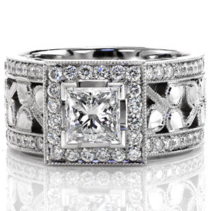 This beautiful design makes a statement with its 1.00 carat princess cut center diamond set with chevron prongs. Micro pavé diamonds detail the square halo, on the side rails of the band, as well as under the center stone. Delicate filigree, milgrain and clovers add the perfect finishing touch. 