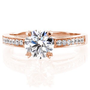 This classic design is stunning with a 1.00 carat round brilliant cut center diamond. The top of the band is detailed with bead set diamonds edged with milgrain for a refined finish. The side profile reveals pockets of filigree set with surprise diamonds.