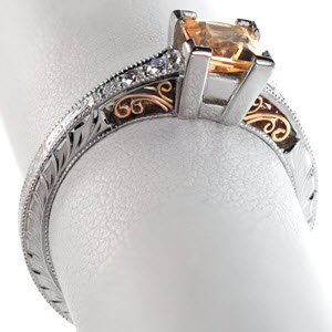 Custom two tone filigree engagement ring in Albuquerque features a white band with rose gold filigree. The peachy-orange sapphire center stone is a perfect compliment to the rose gold details. The band is carefully decorated with hand engraving and diamonds. 