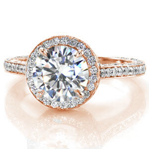 This stylish halo accentuates the 1.50 carat round brilliant diamond, giving this fashion-forward design a visually bigger appearance. Each angle lavishly set with micro pave diamonds heightens the exquisite center diamond. The raised cathedral elevates the ring giving the design a regal statement. 
