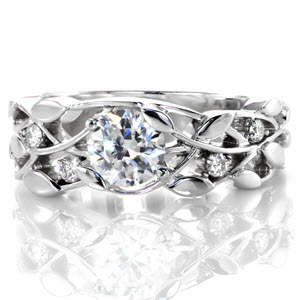 Rochester custom engagement ring with a round diamond center and a nature inspired leaf and vine patterned band.