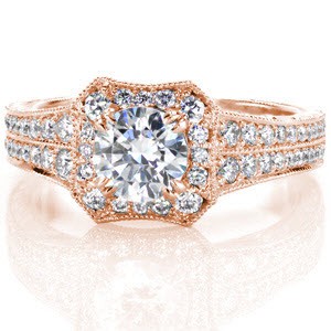 The Bergenia design conveys timeless elegance with a bevel-edged square halo which frames a .70 carat round brilliant center diamond. Sweeping hand engraving pairs with the hand formed filigree, placed perfectly in six areas on the ring. Milgrain is found on every edge completing the heirloom piece.