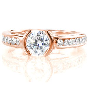 Novara is a clean, classic design with a contemporary edge. The 0.70 carat round brilliant center diamond is set in a half bezel, and the smooth band has channel set round diamonds along the top. The side profile reveals charming hand-formed filigree loops which are individually soldered into place.