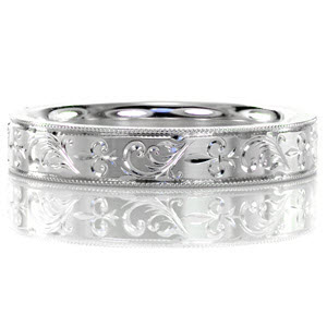 The Fleur De Lis engraved band is a beautiful display of fleur de lis and swirl flourish hand engraving. The 14k white gold band is finished in a high polish and detailed with milgrain edges. A slightly rounded inside band is designed for the utmost comfort.